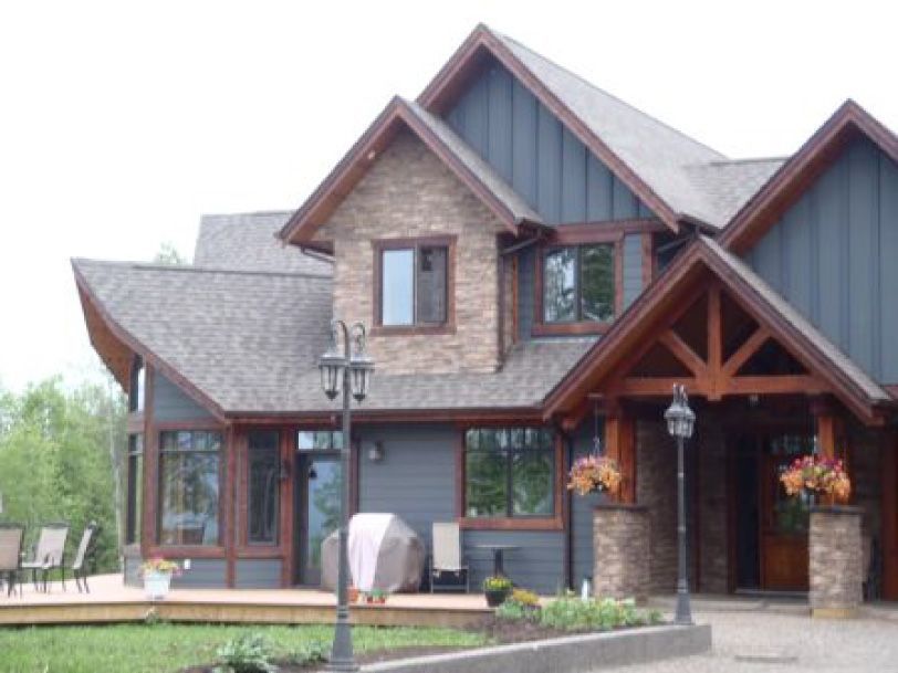 A large house with a lot of windows and a wooden roof