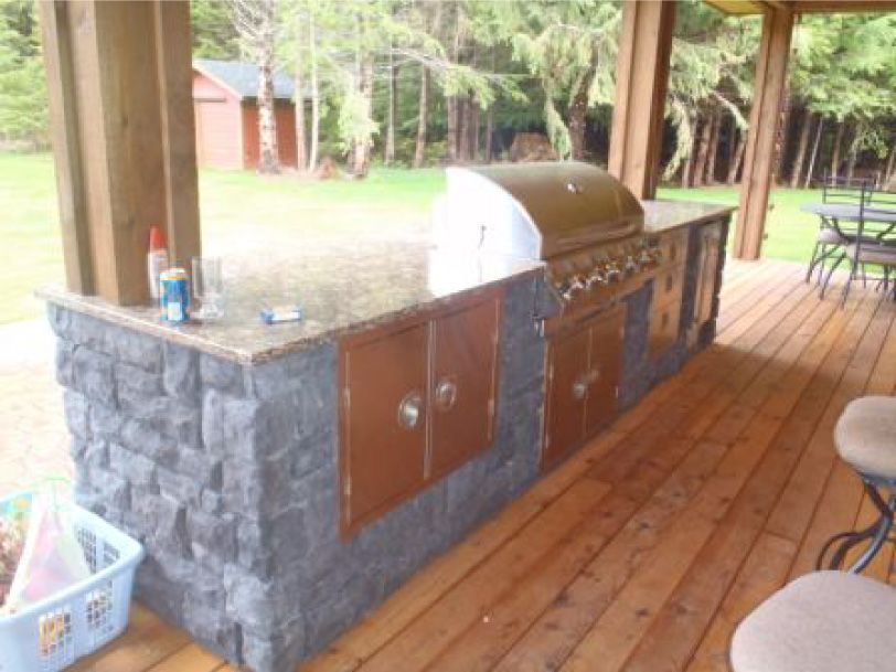 A wooden deck with a grill on top of it