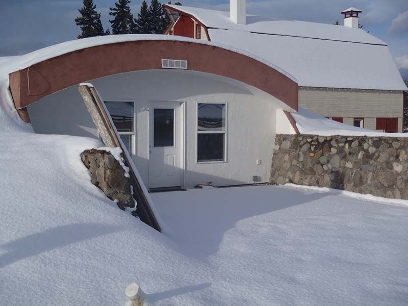 A snowy house with a sign that says cellar