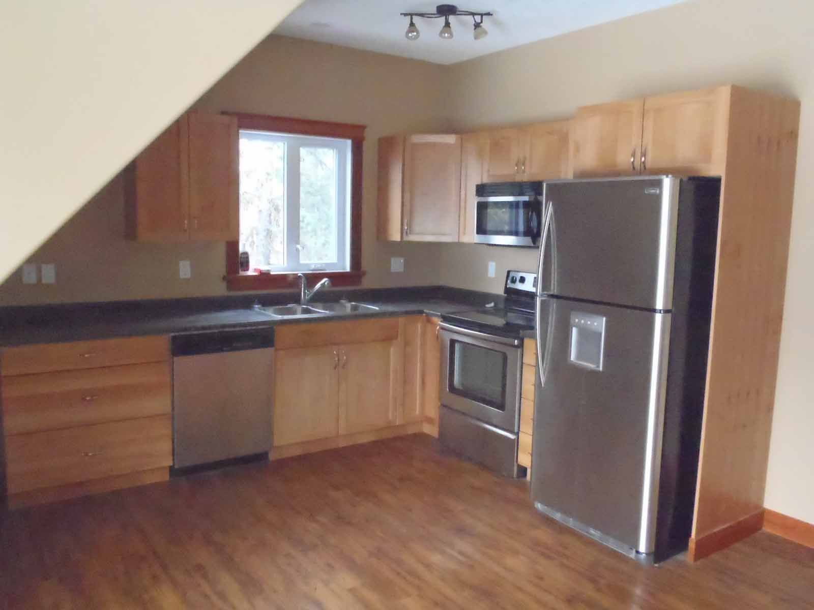 A kitchen with stainless steel appliances and wooden cabinets