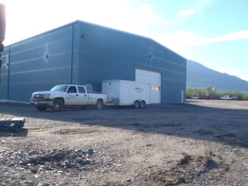 A white truck is parked in front of a large building