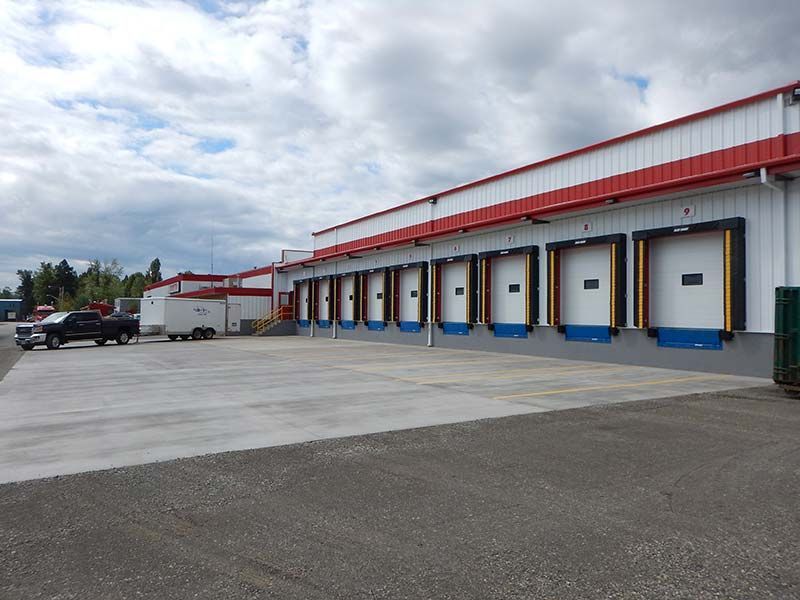 A warehouse with a lot of trucks parked in front of it