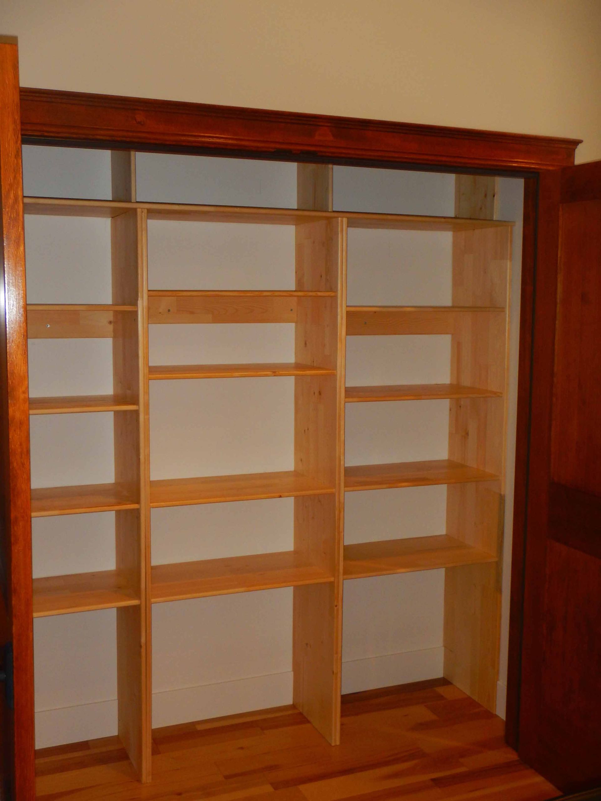 A closet with wooden shelves and a wooden door