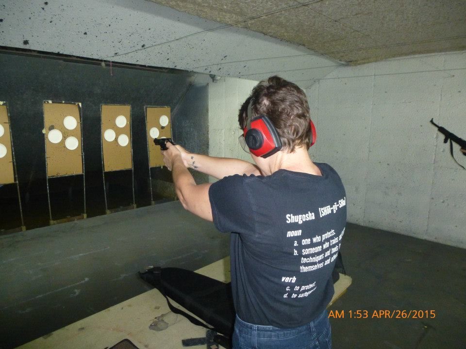A man and a woman are practicing self defense in a gym.