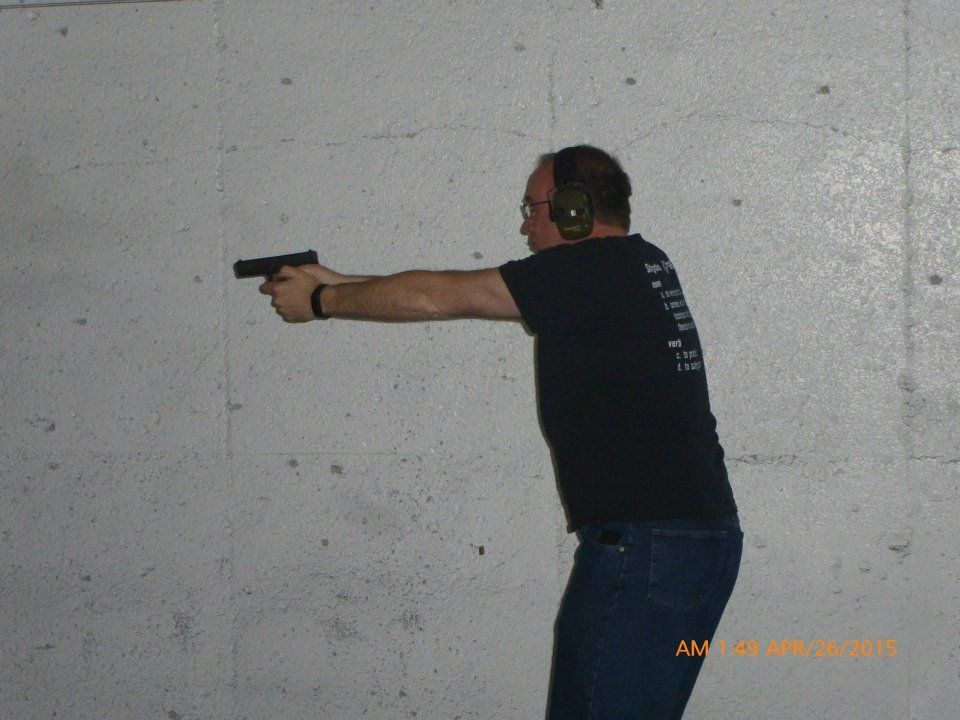 A man and a woman are wrestling on a mat in a gym.