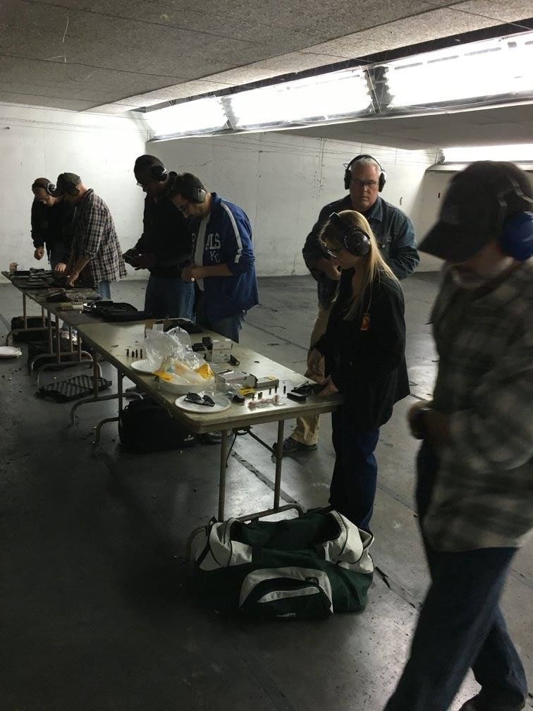 A group of people are standing around tables in a room.