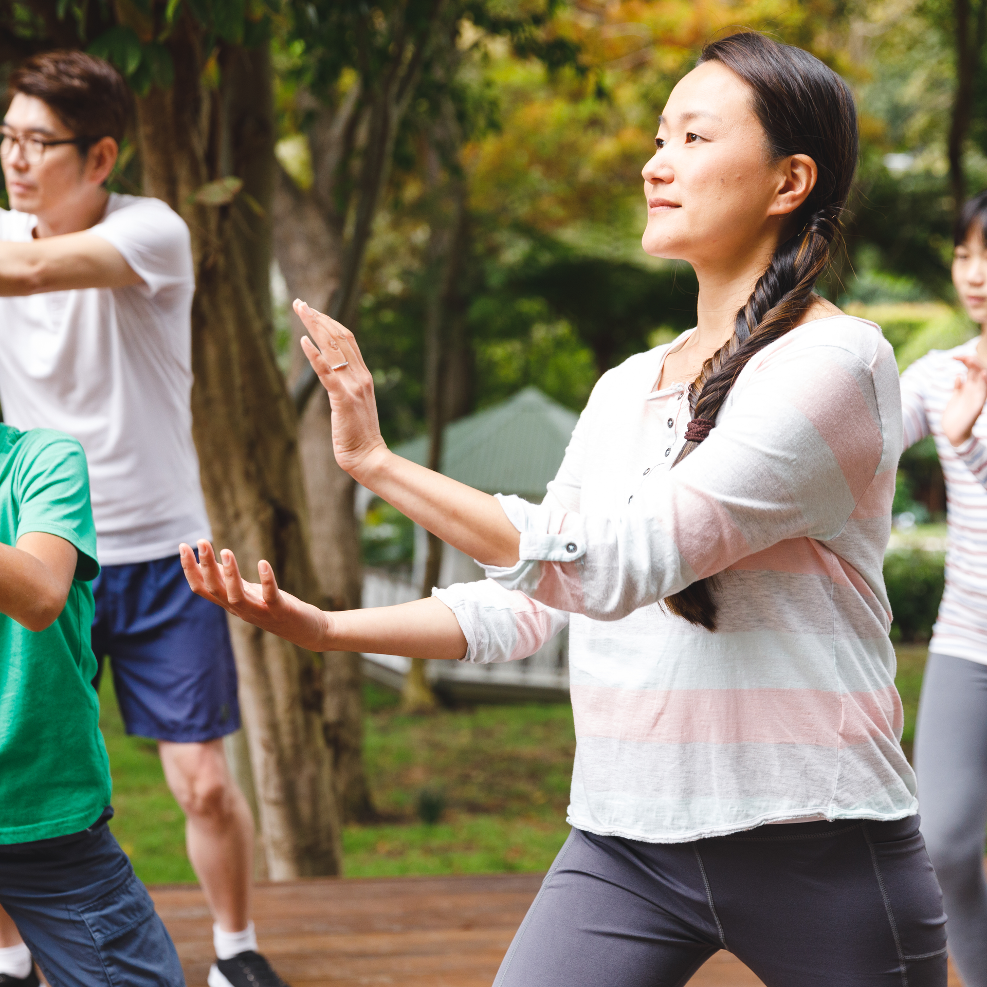 A group of people are practicing martial arts in a park