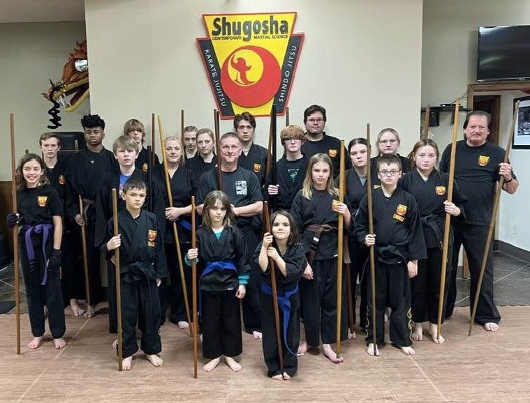 A group of children are practicing martial arts in a gym.