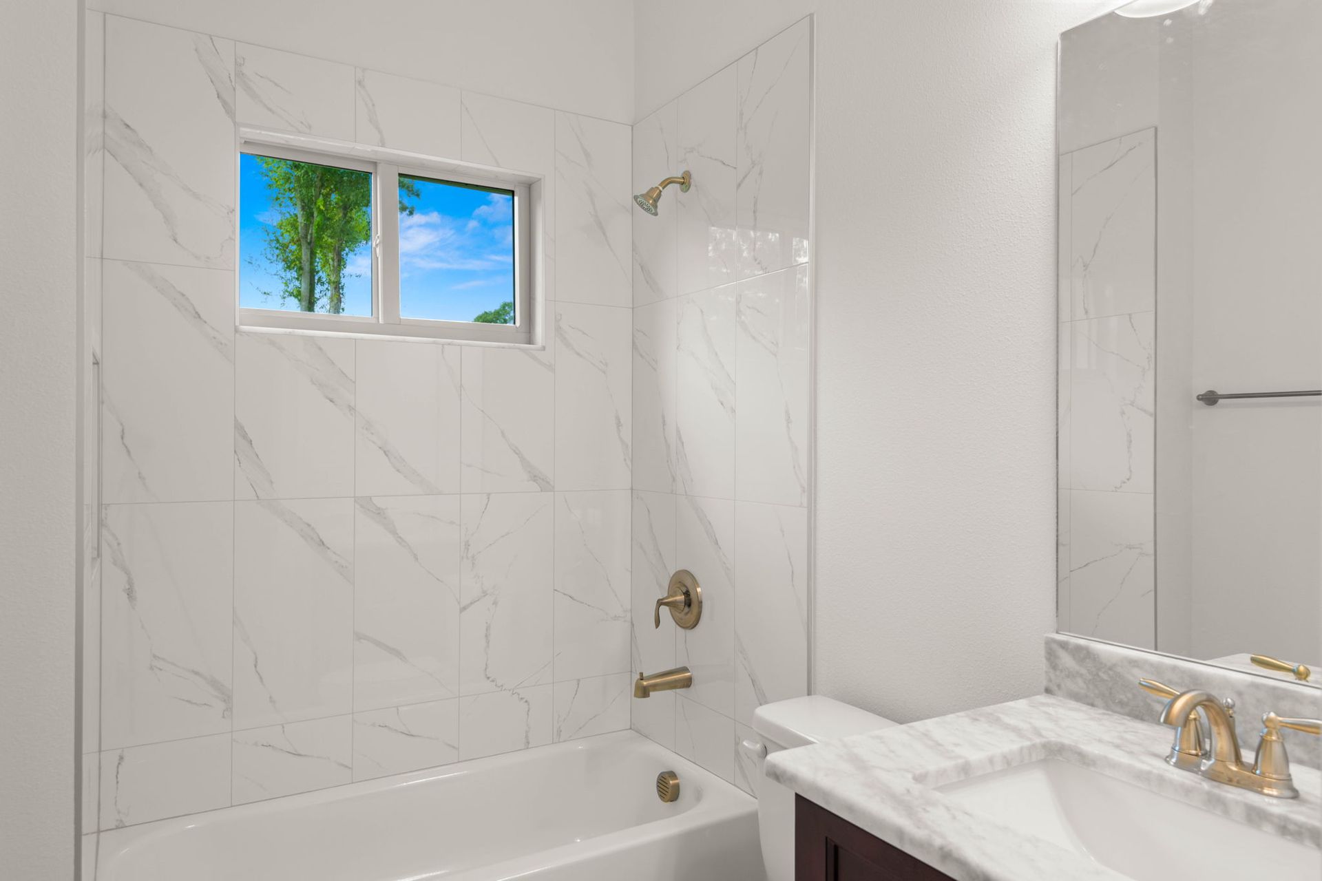 Open-concept kitchen and living area with black island, white cabinets, and large glass doors leading to a pool.