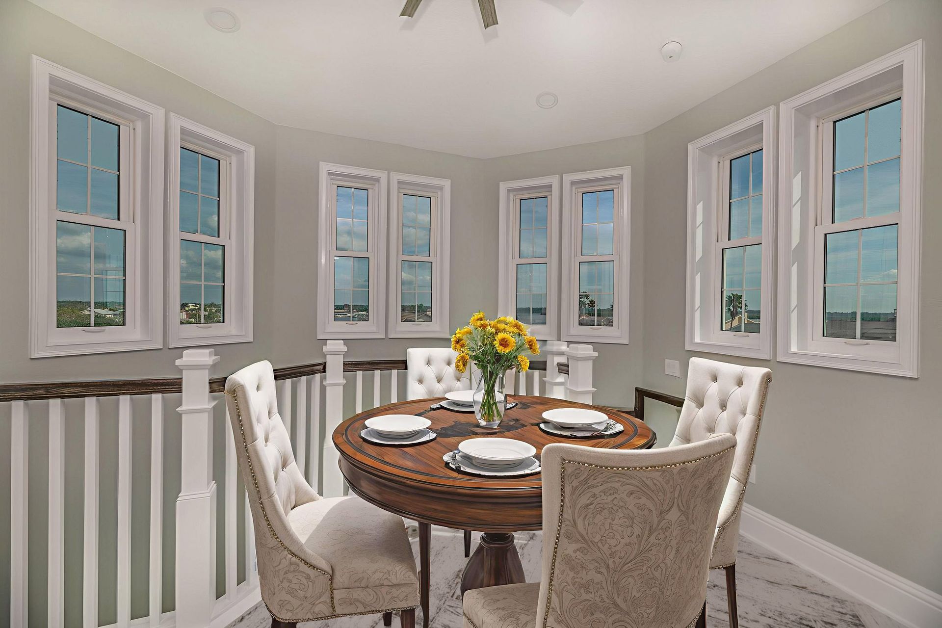 Bathroom with a claw-foot tub by a window overlooking a tree, shower with white tiled wall, and blue vanity.