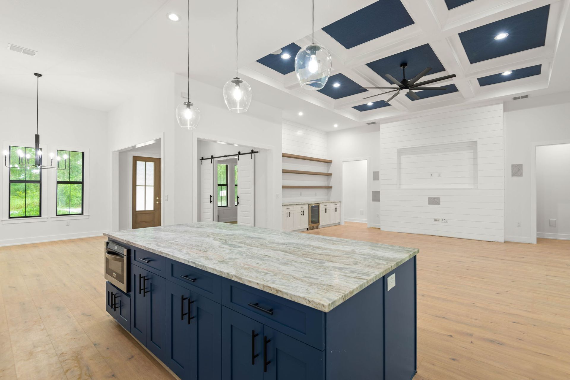 Modern kitchen with blue island, granite countertop, and blue ceiling accents.