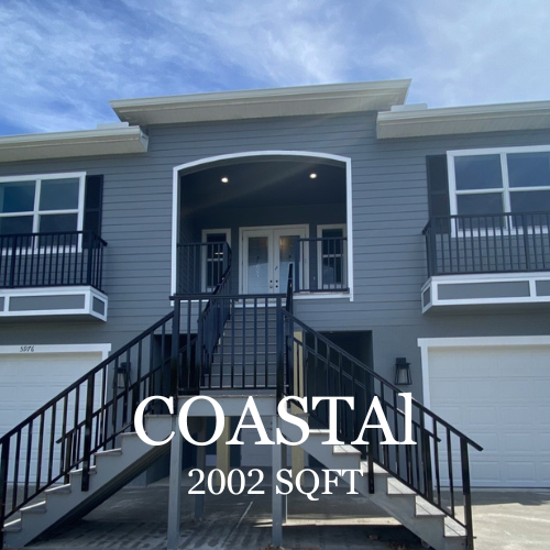 A gray two-story Coastal-style home with white trim, two garage doors, and a central staircase leading to a front entry.