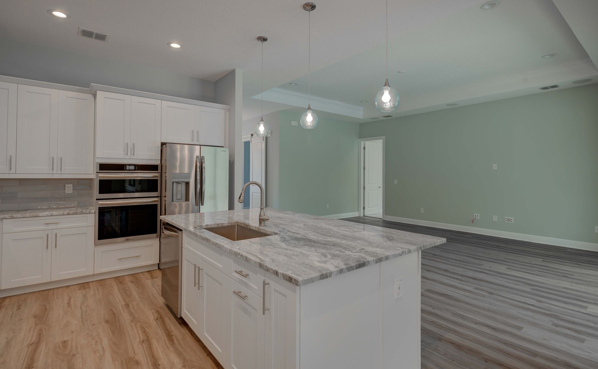 Bright, modern bathroom with glass shower, double vanity, and large windows. White and gold accents.
