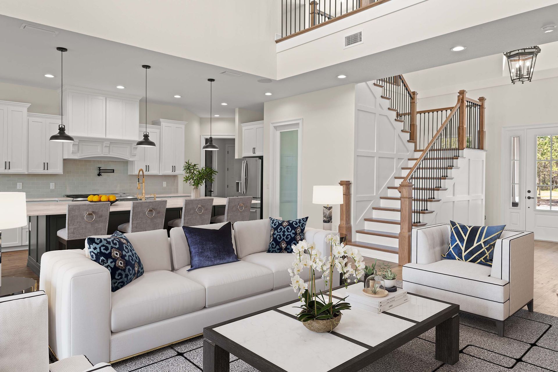 Living room with white sofa, kitchen, staircase, and modern decor.