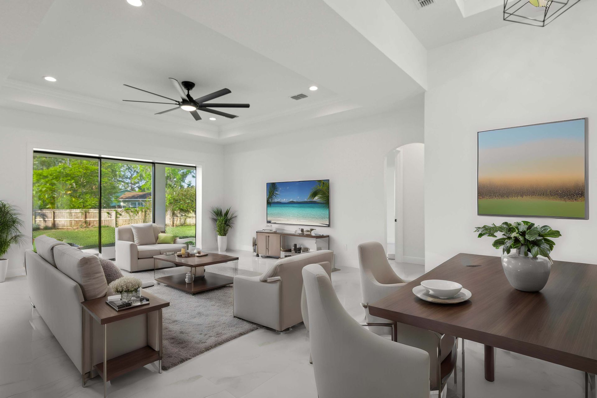 Open-concept kitchen and living area with black island, white cabinets, and large glass doors leading to a pool.