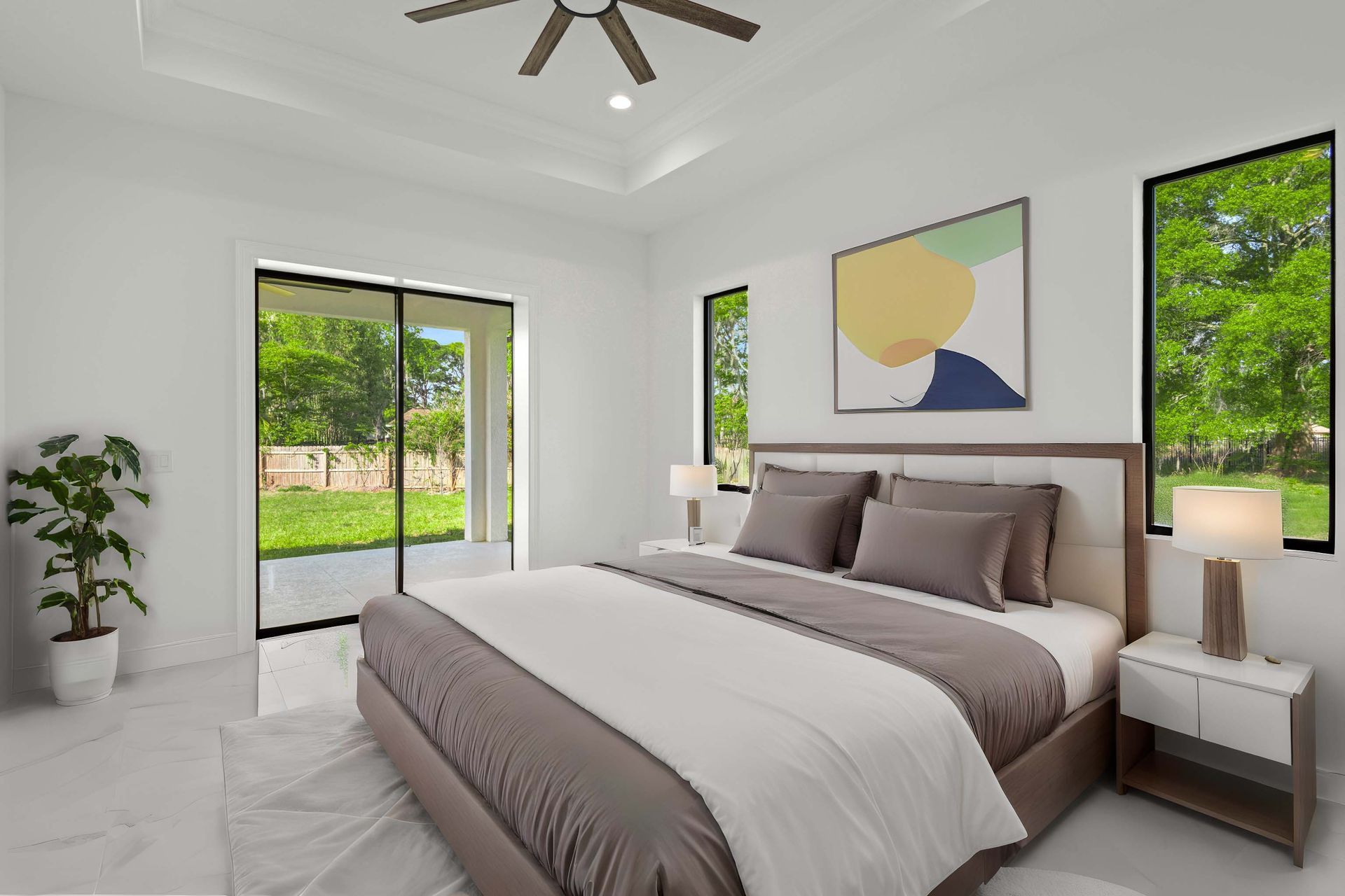 Bright, modern bathroom with glass shower, double vanity, and large windows. White and gold accents.