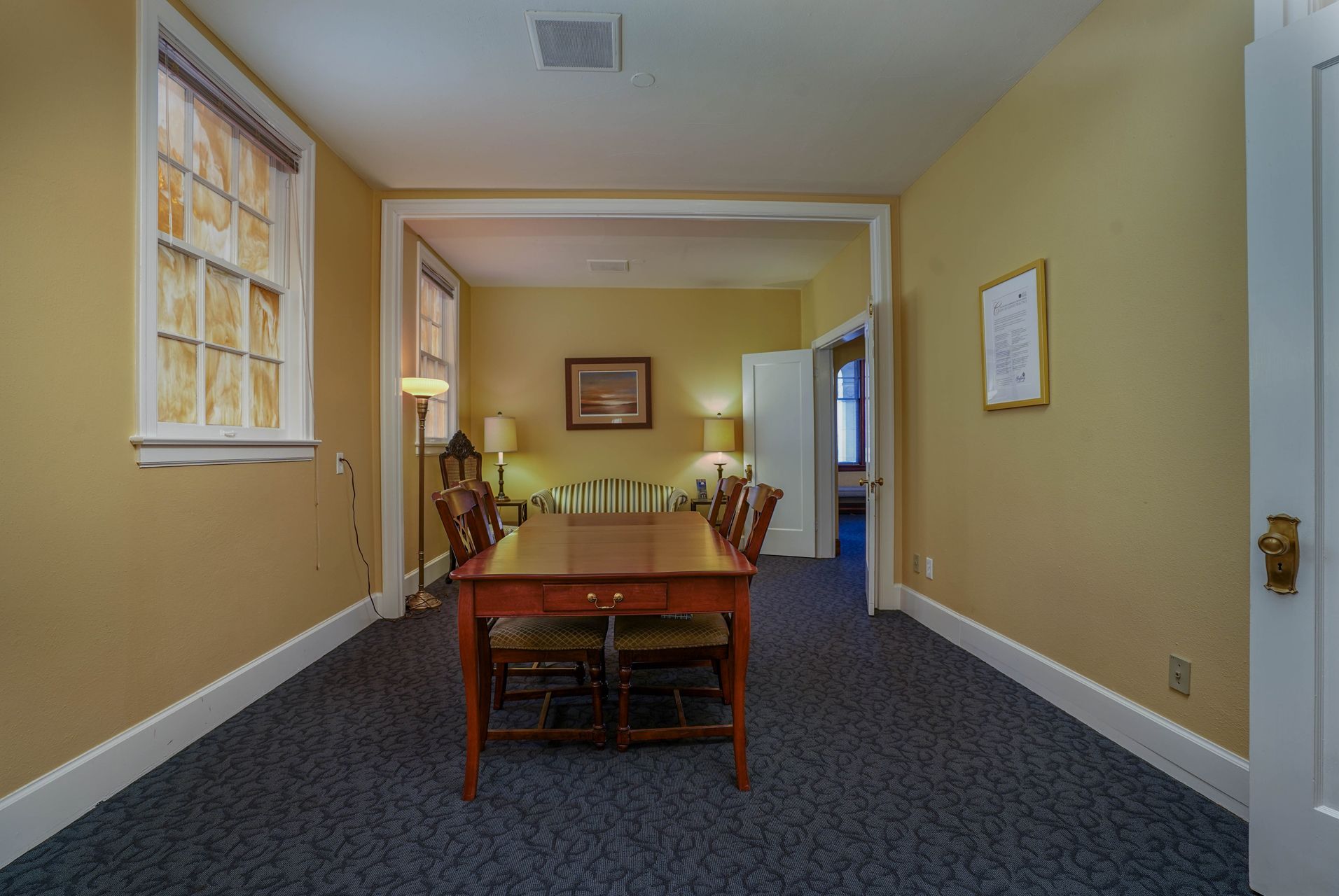 A large room with a table and chairs in it.