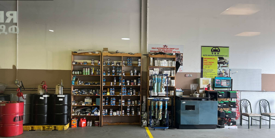 A garage with a lot of shelves and barrels of oil