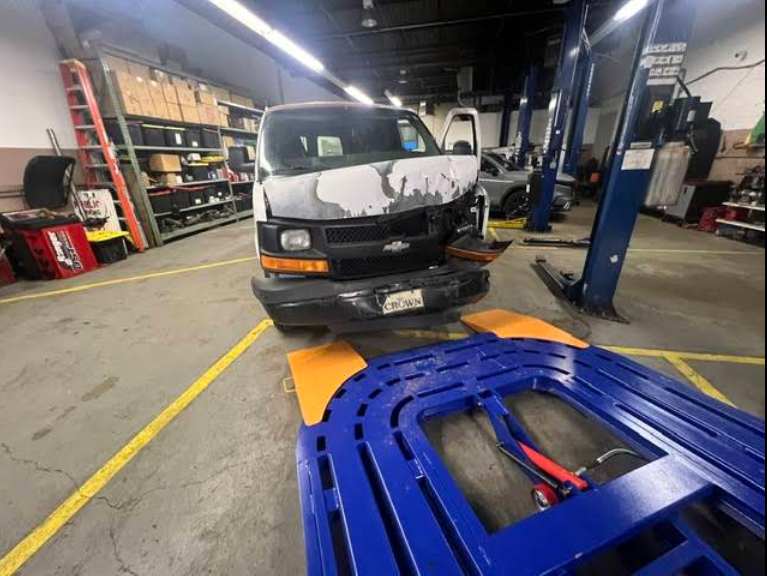 A white van is on a lift in a garage