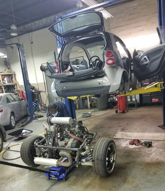 A smart car is being worked on in a garage
