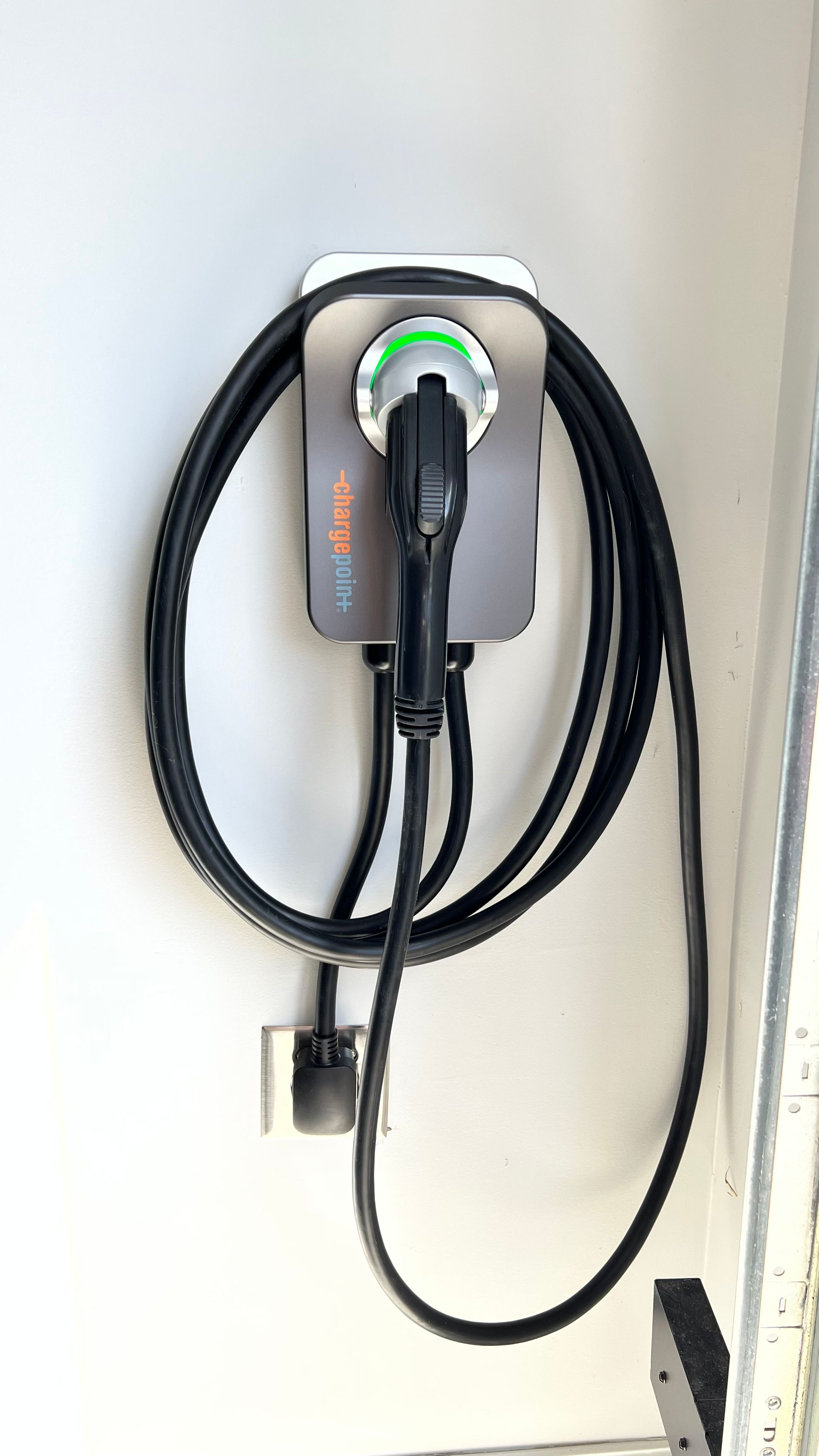 A close up of a charging station with a cable attached to it.