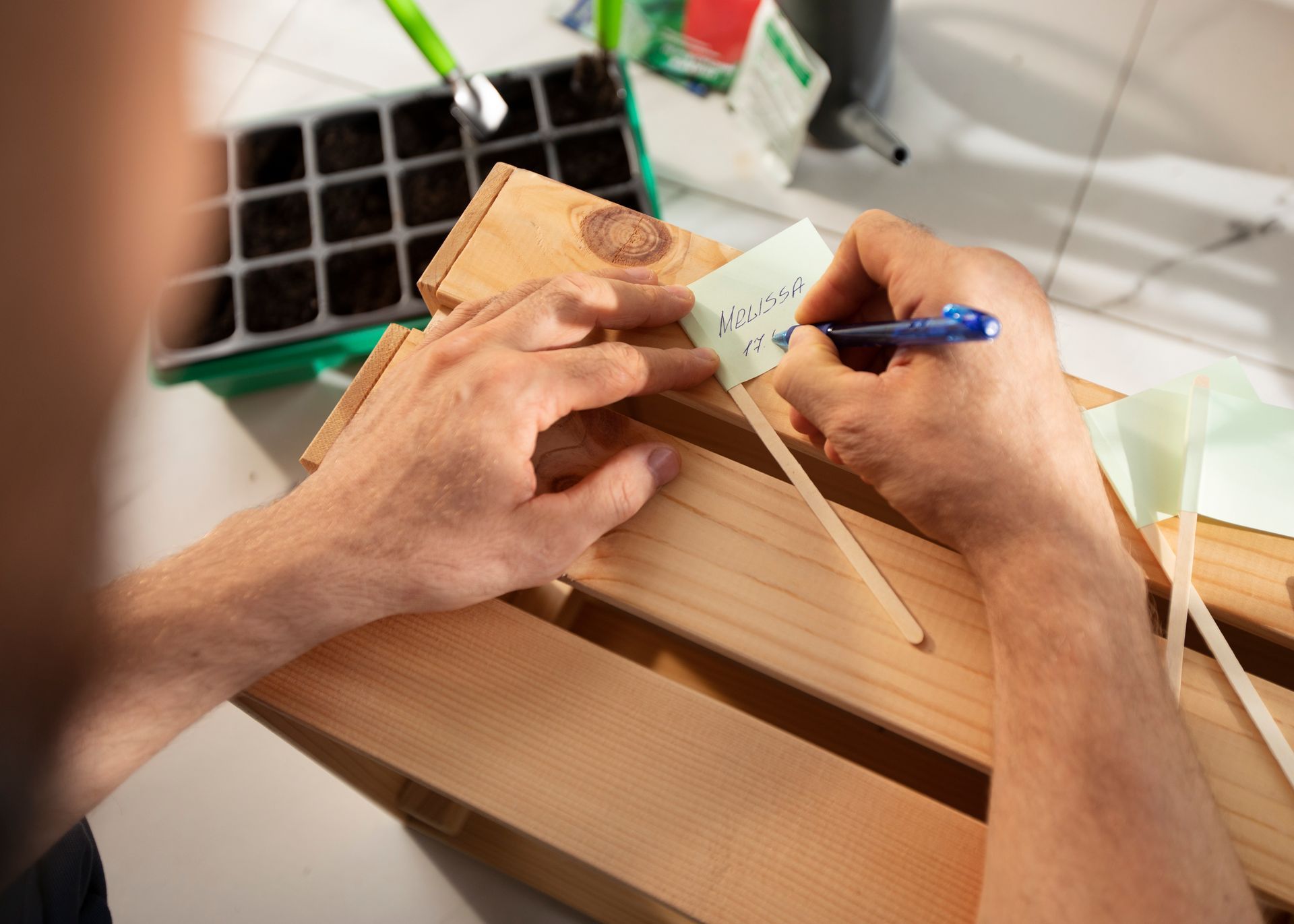 Persona escribiendo en una etiqueta con la etiqueta