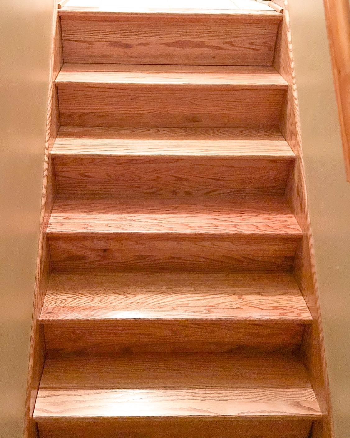 Wooden staircase viewed from above, leading upwards.