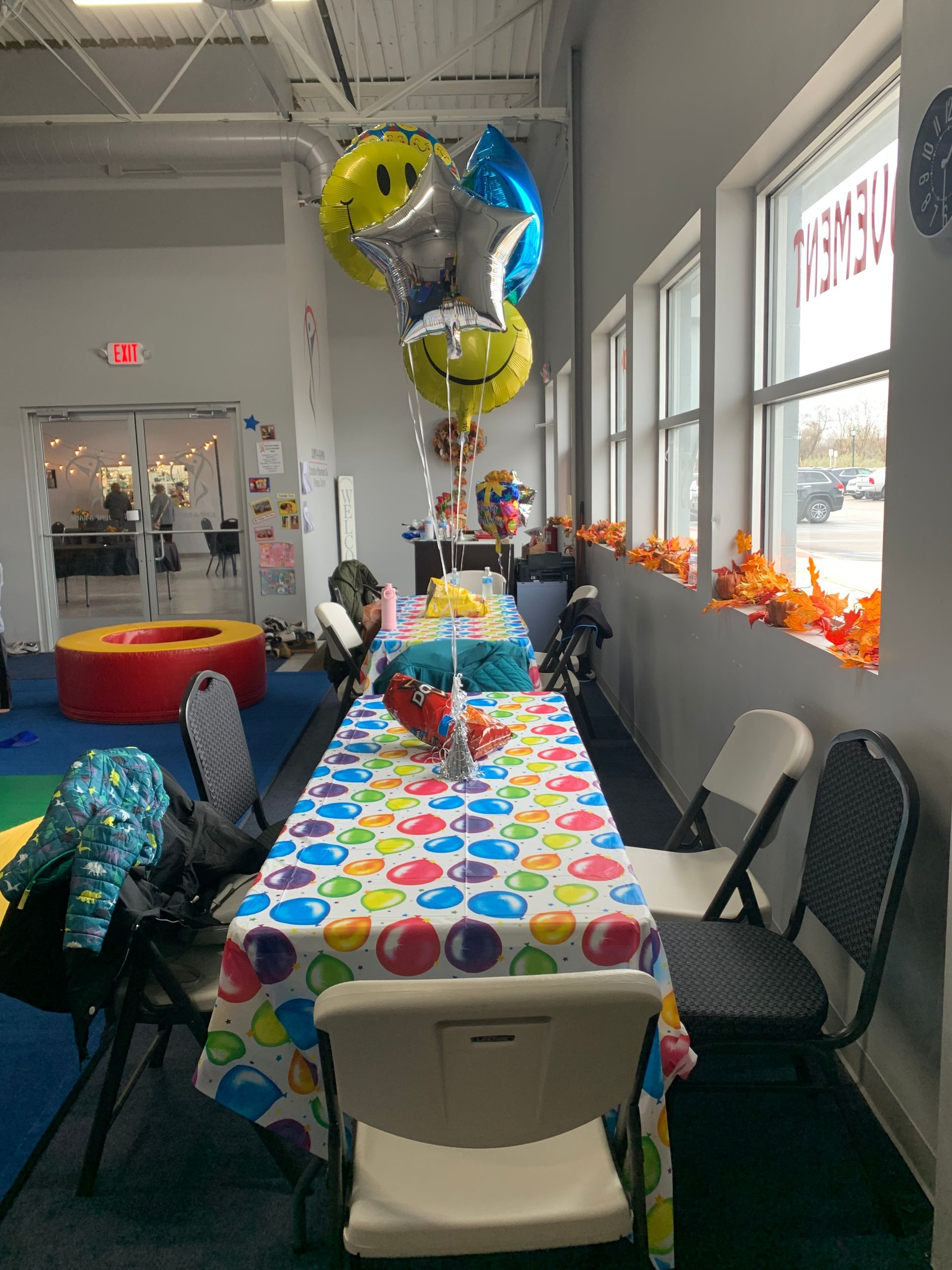 A room with a table and chairs and balloons on it