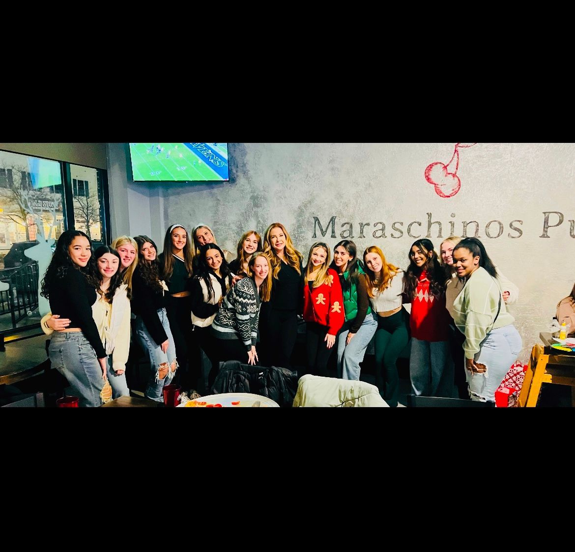 A group of young women are posing for a picture in a restaurant.