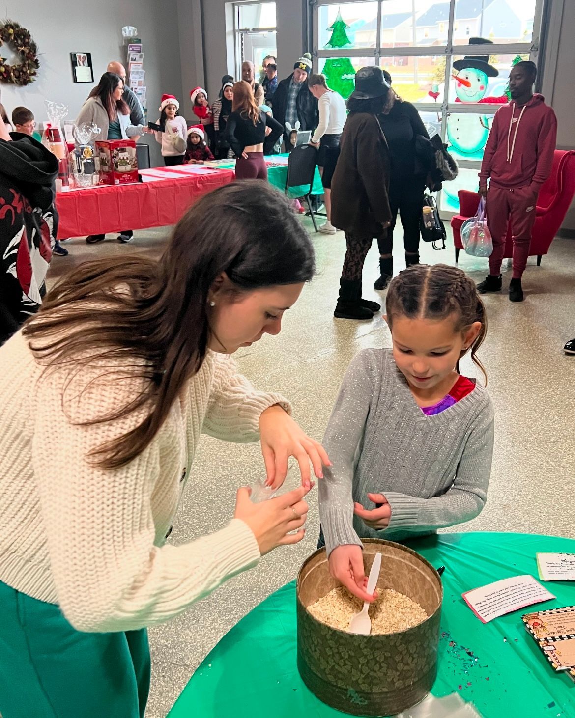 A woman and a little girl are sitting at a table in a room.