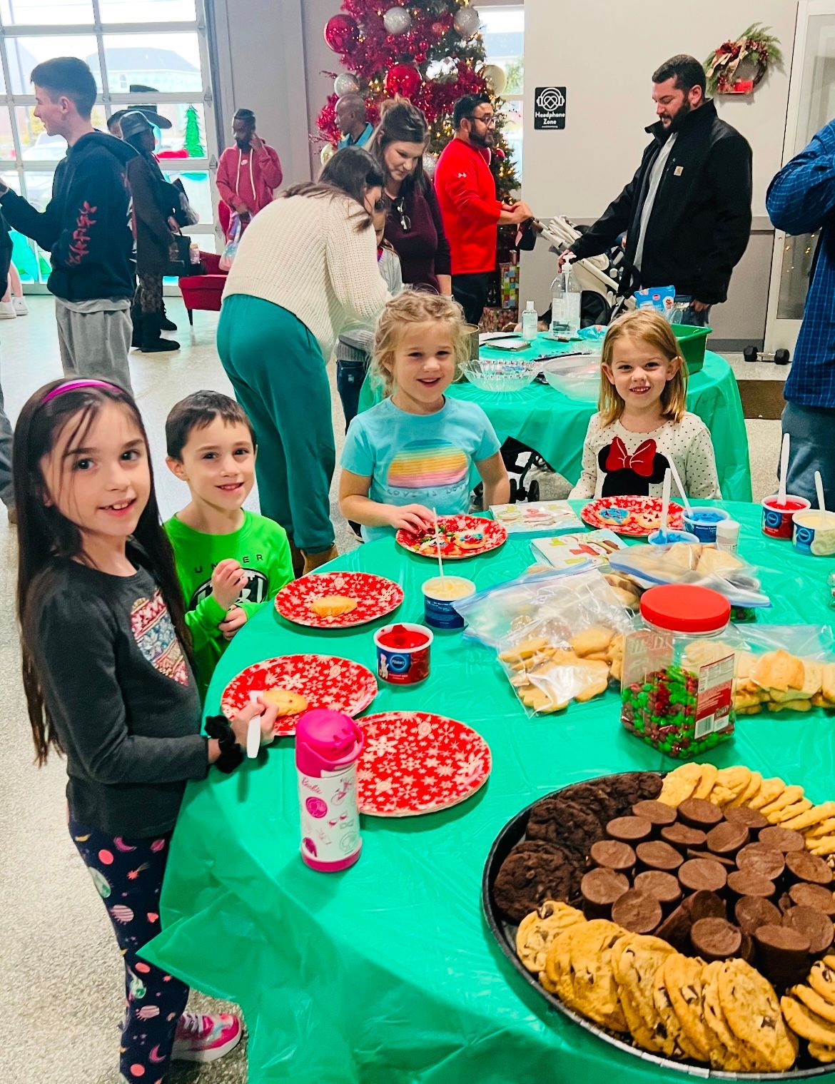 A group of children are sitting at a table with plates of food.