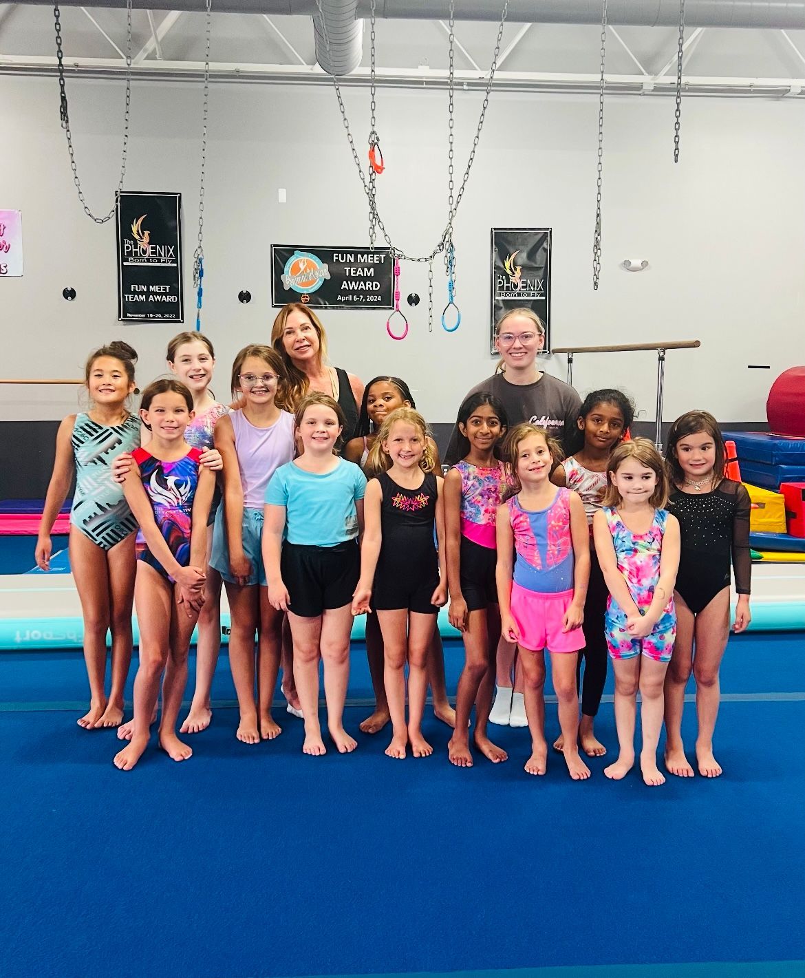 A group of young girls are posing for a picture in a gym.