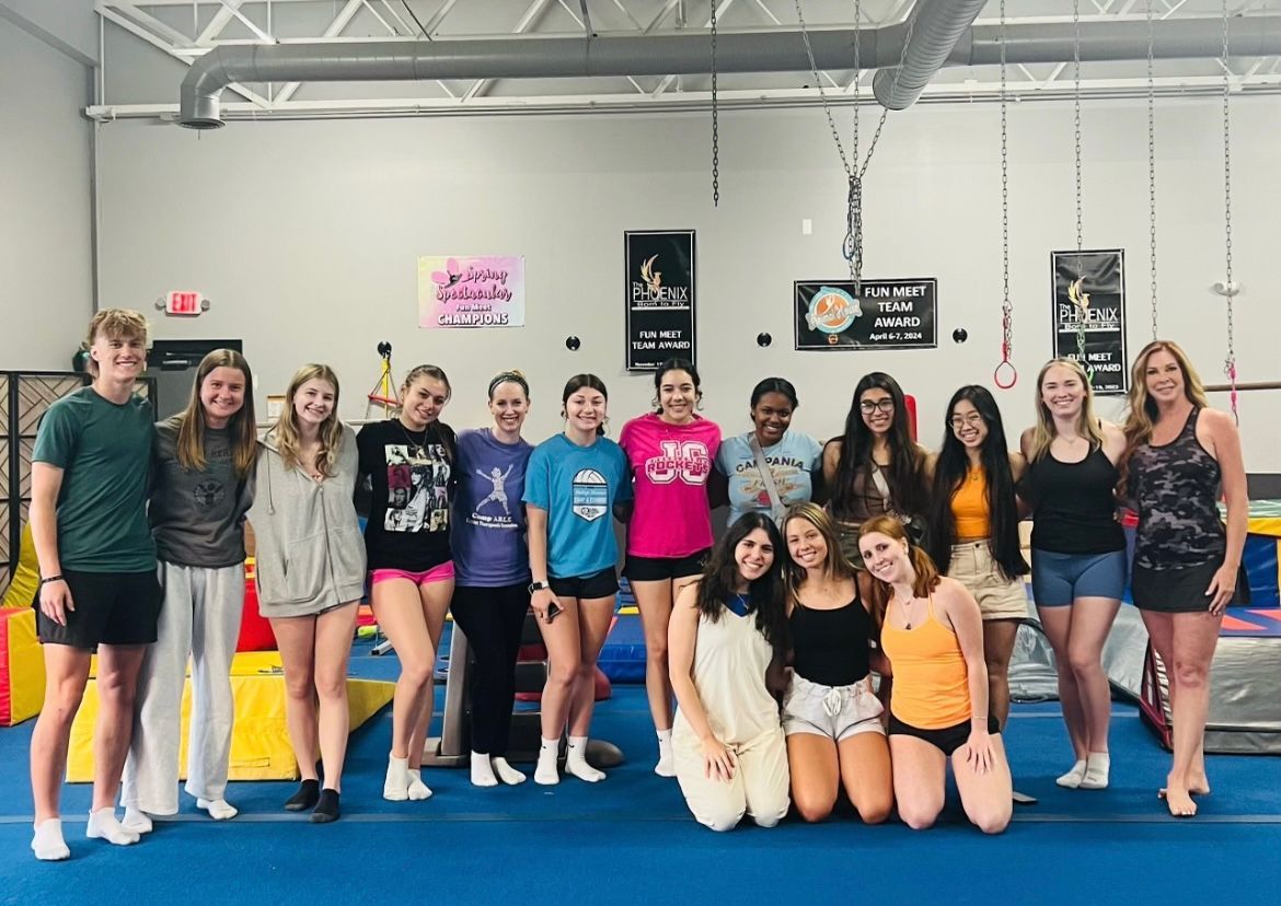 A group of young people are posing for a picture in a gym.
