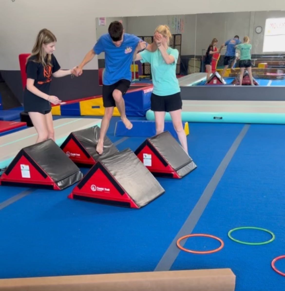 A group of people are doing gymnastics in a gym