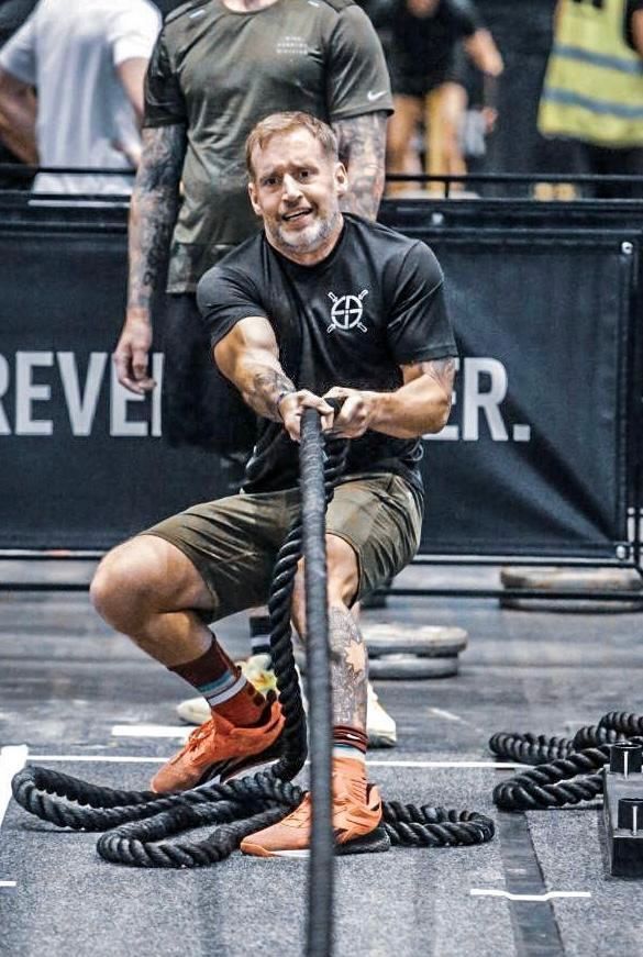 A man is pulling a rope in a gym.