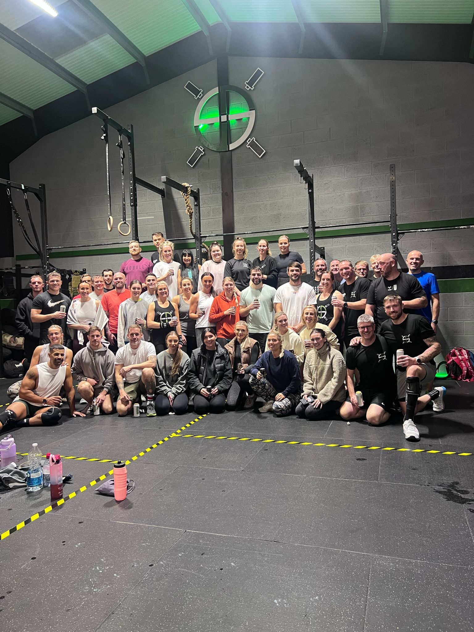 A large group of people are posing for a picture in a gym.