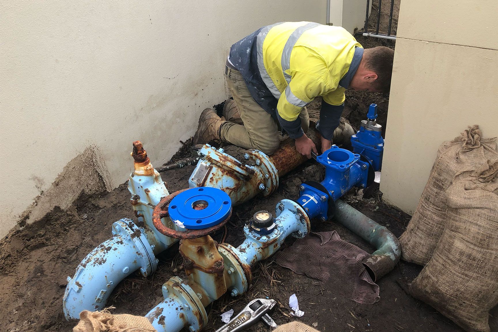 Plumber Repairing Rusted Blue Pipes

