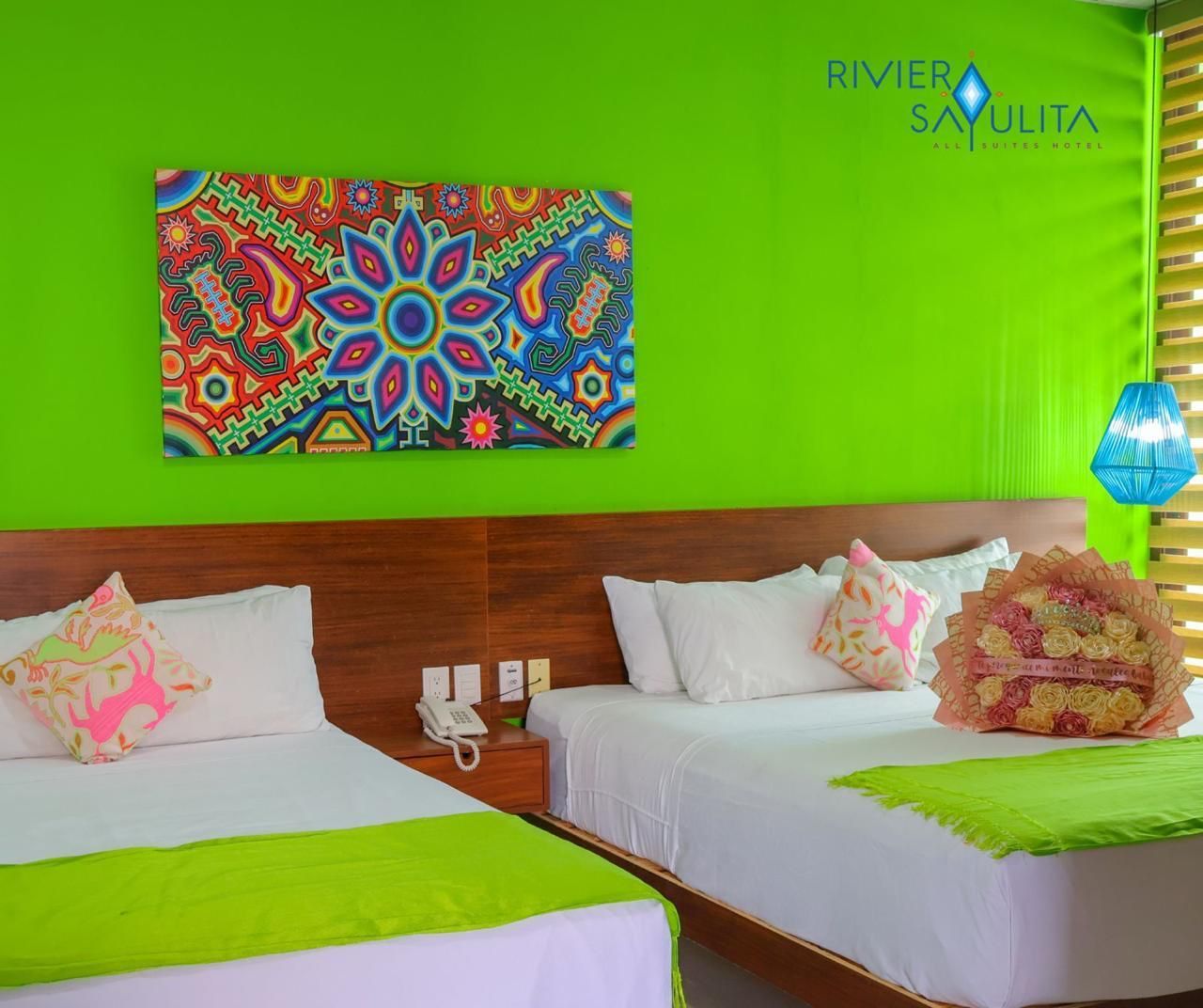 A hotel room with two beds and a painting on the wall