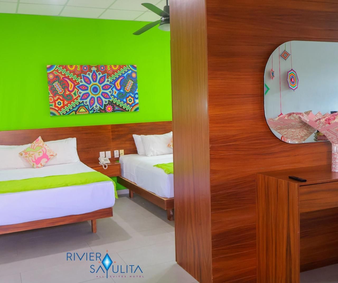 A hotel room with two beds and a mirror