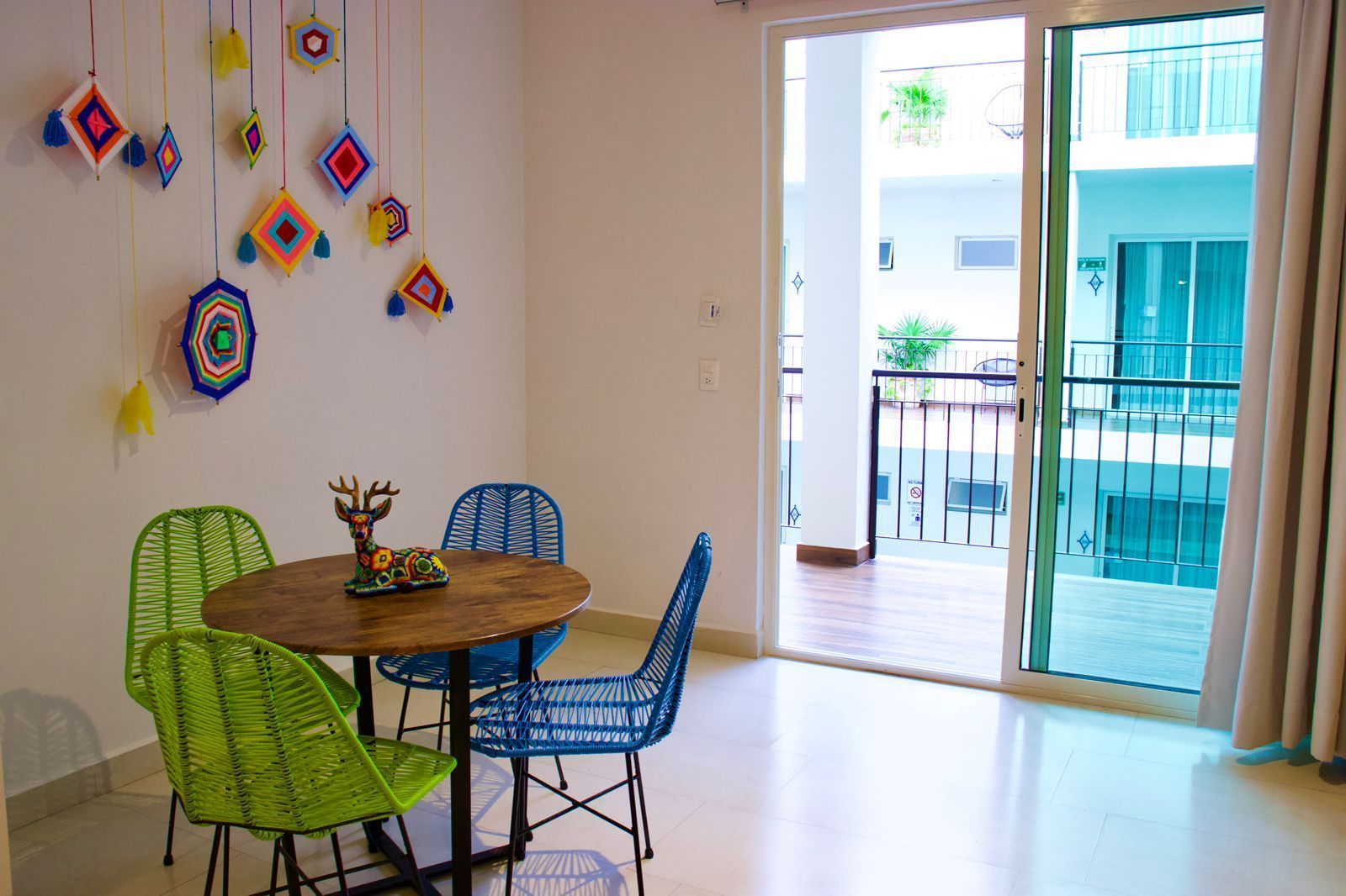 A living room with a table and chairs and a sliding glass door leading to a balcony.