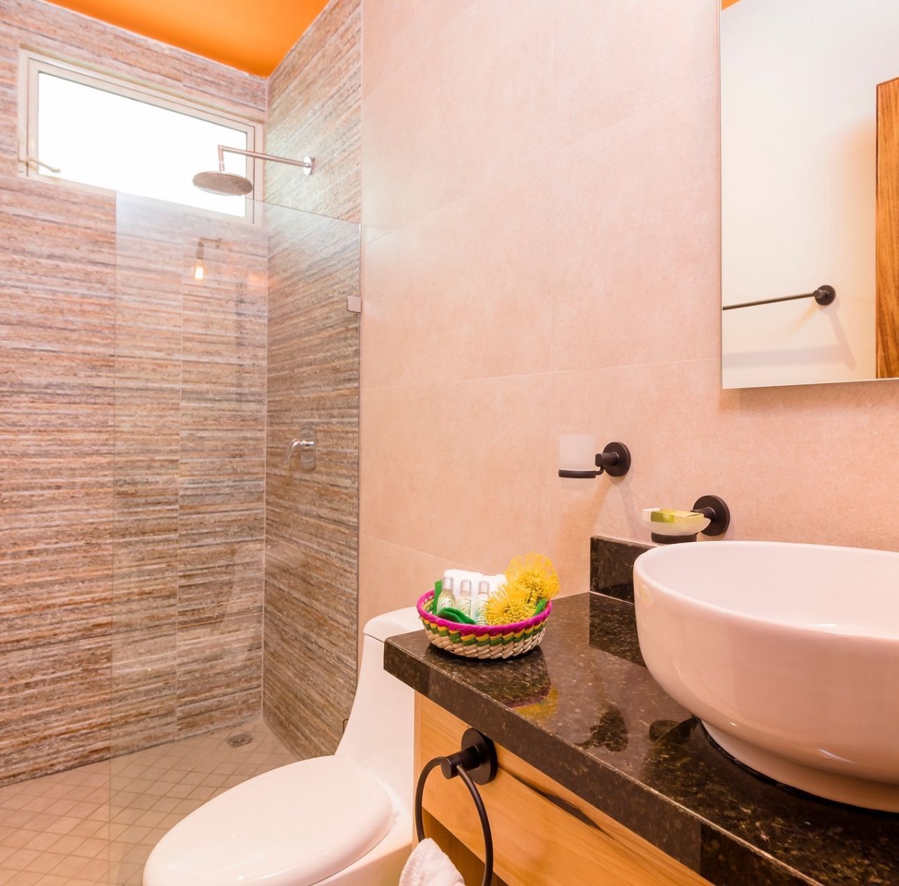 A bathroom with a toilet a sink and a shower