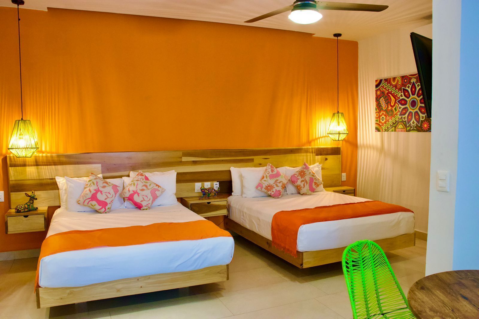 A hotel room with two beds and a ceiling fan.