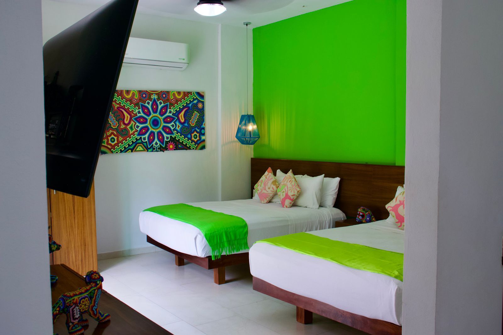 A hotel room with two beds and a flat screen tv.