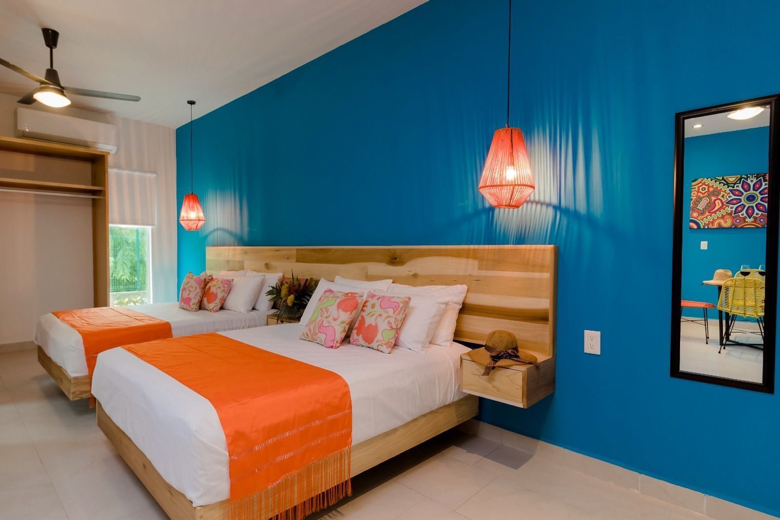 A hotel room with two beds and a mirror.