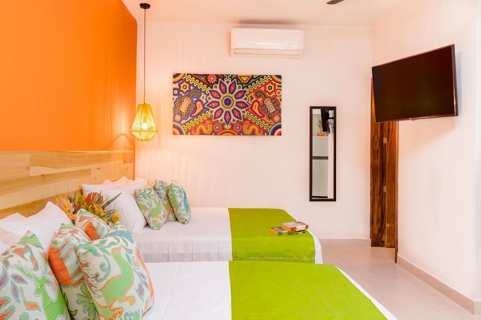A hotel room with two beds and a flat screen tv.