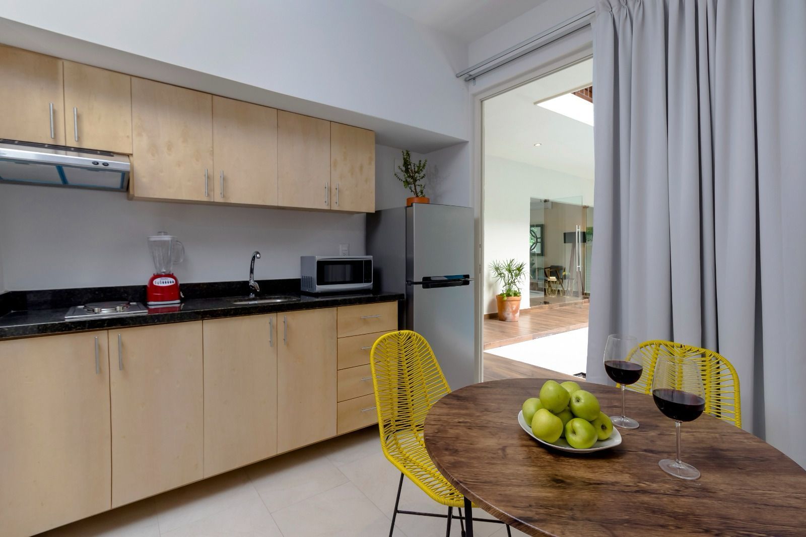 A kitchen with a table and chairs and a refrigerator.