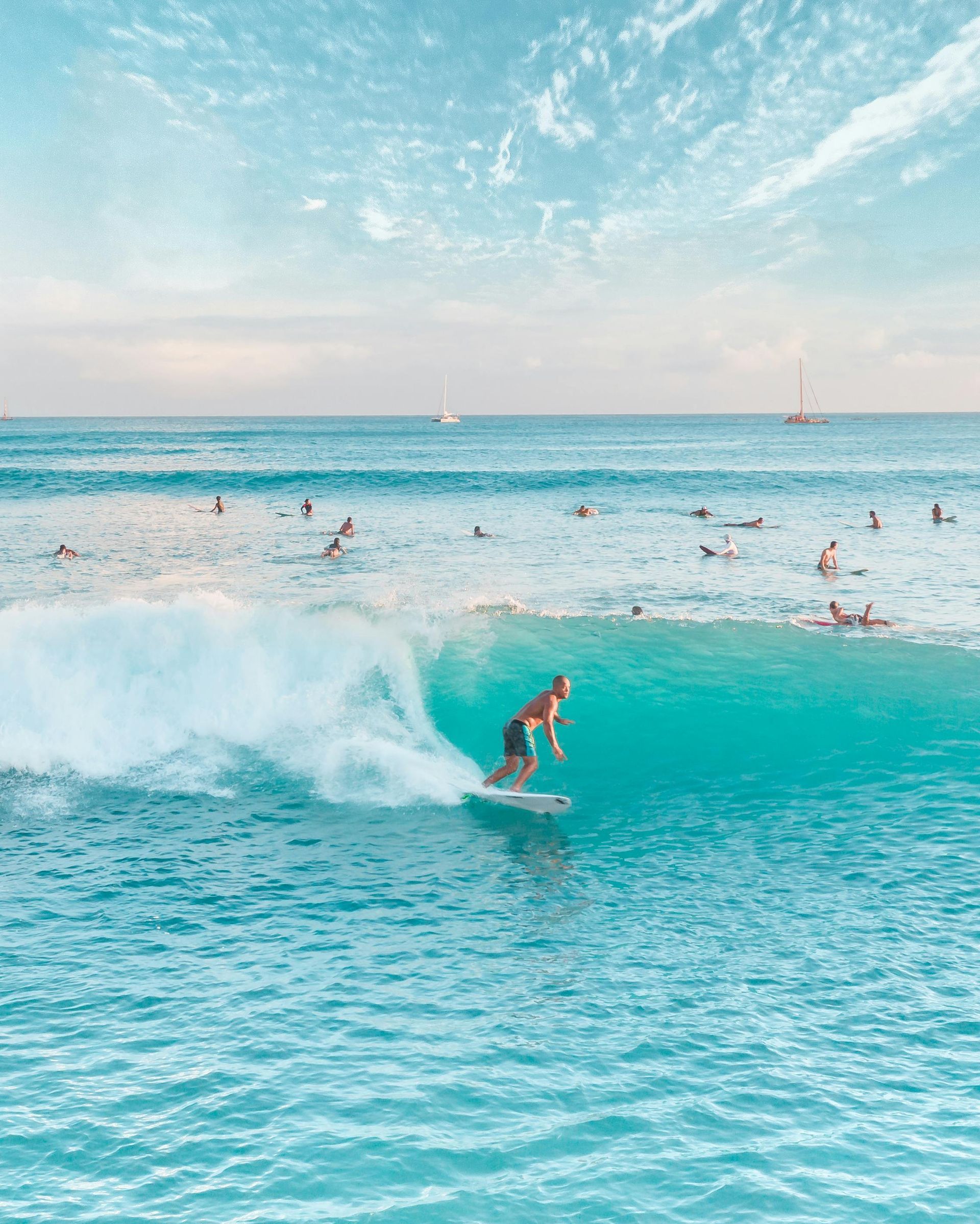 A man is riding a wave on a surfboard in the ocean.