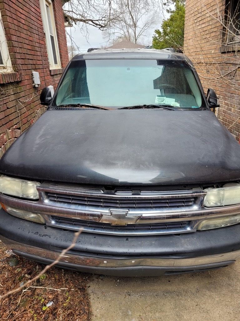 Black Chevrolet SUV parked in front of a brick building.