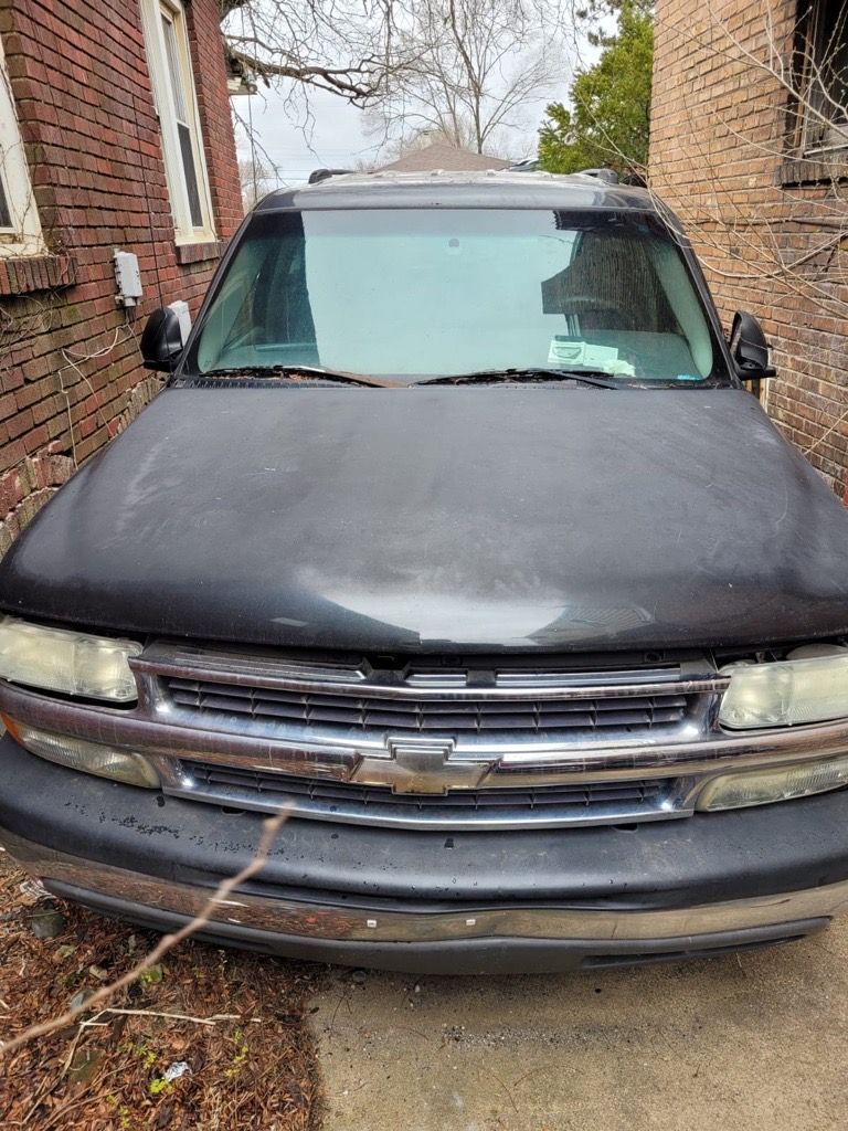 Black Chevrolet SUV parked in front of a brick building.