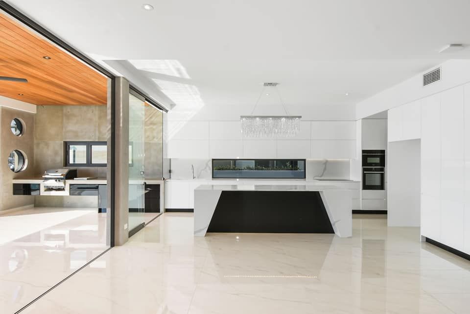 A Modern Kitchen With White Cabinets and a Black Island — Simonetto'S Cabinets & Joinery in Nambour, QLD